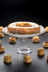 Alzatina di cristallo con aspic tra i vol-au-vent ripieni su un tavolo nero