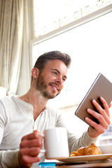Smiling middle age man with tablet and coffee