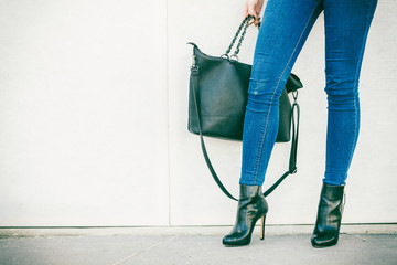woman legs in heels shoes handbag in hand - obrazy, fototapety, plakaty