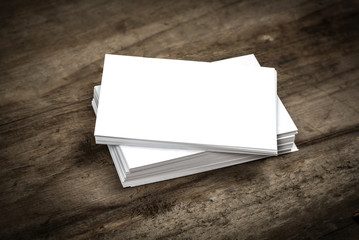Close up pile of blank business card on wooden background.