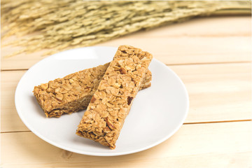 Oatmeal, almond and honey cereal bar on white plate.