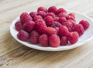 handful of fresh raspberries lying on a plate