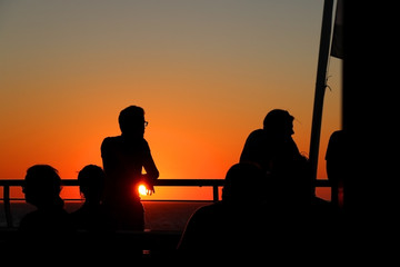 Naklejka na ściany i meble People enjoying sunset on the ferry. 