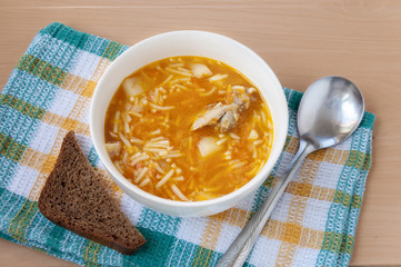 Chicken soup with noodles with black bread  
