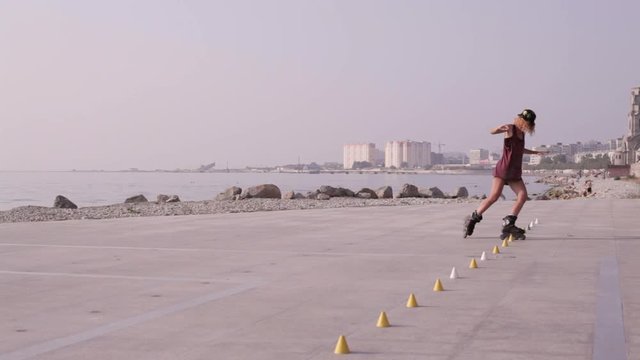 Young Beautiful Girl Rollerblading In A Park.