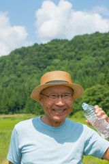 Fototapeta premium 散歩中のシニアが水分補給