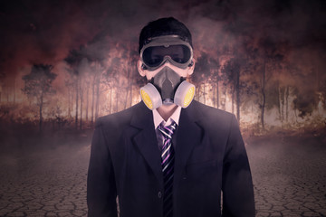 Man with gas mask and forest fire