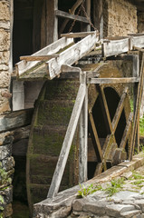 Old retro wooden mill wheel powered by water closeup