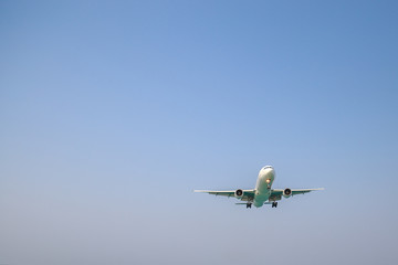 a lone white plane in the blue sky