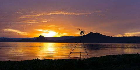 Tropical golden sunset on the Lake Taal, Luzon Island, Philippines. Horizon over the mountains and beautiful lake at sunset.