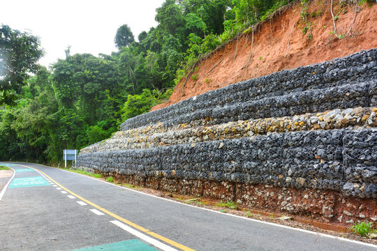 Gabion wall made of stones in the steel mesh, used as a fence on a slope for protection landslide