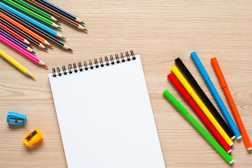 Obraz premium Pencils, crayons and notebook on a desk.
