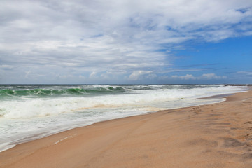 Fototapeta na wymiar Wonderful sandy beach with slightly waves of Atlantic ocean, Portugal