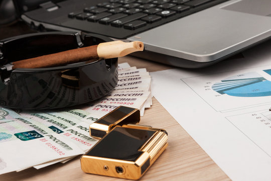 Working businessman desk, Lighter and laptop, cigar and money