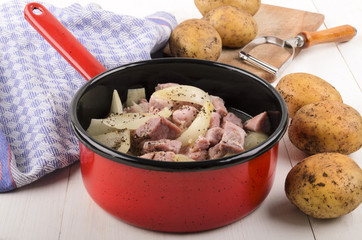 cooked onions and bacon cubes with coarse pepper in a pot