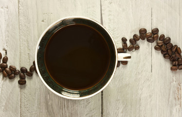 Vintage tasse de café noir avec des grains de café formant une vague