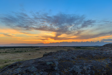 Golden sunset in the valley and on the rocks/Golden sunset in the valley and on the rocks with the rays of the sun, clouds and flowers