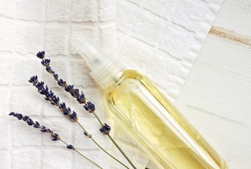 Spray bottle of oil, white towel, lavender dried flowers. Natural skincare and sun-protector. Empty space, top view. © Anna_ok