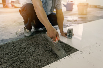 Workers use tile work equipment, renovation - handyman laying ti