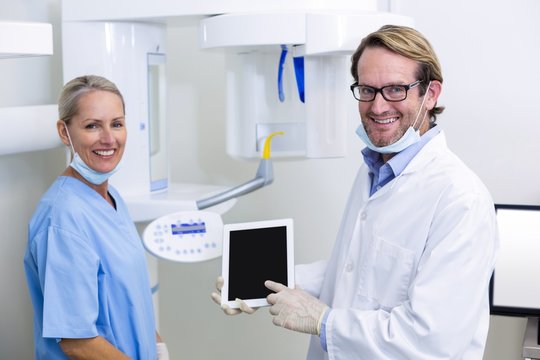 Dentist and dental assistant working on digital tablet