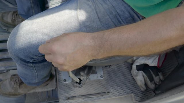 The driver maneuvering the lever of the forest harvester that transfers the logs on the ground
