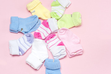 Cotton baby socks for newborn on a colorful pink background. Copy space for text. Top view