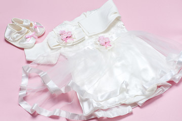 Clothes for baby girl on a pink background. Copy space for text