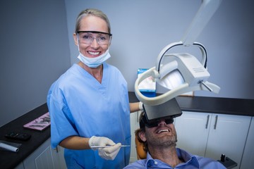 Fototapeta na wymiar Man using virtual reality headset during a dental visit