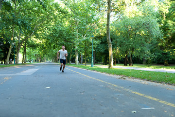 A handsome young man jogging in a park	