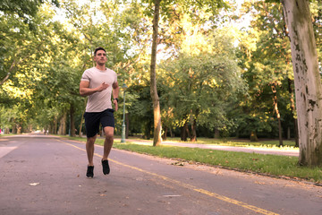 Fototapeta premium A handsome young man jogging in a park 