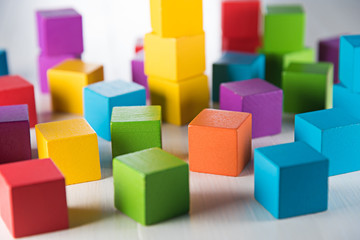 Colorful wood cube building blocks on white wood floor