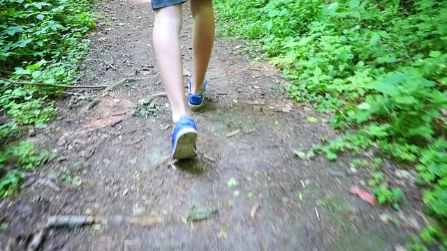 Slow Motion Male Trail Runner Running In The Forest On A Trail.Close-up On Running Shoes.