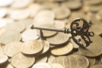 skeleton key lying on gold coins