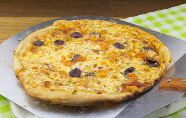 Olive and anchovy pizza on metal spatula