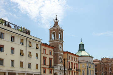 Fototapeta na wymiar clock tower and old buildings Piazza Tre Martiri Rimini Italy