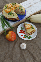 Vegetable cake with zucchini, tomatoes, cheese, onions and garlic served on plate