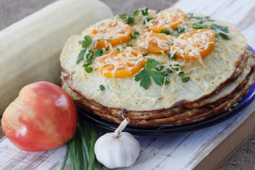 Vegetable cake with zucchini, tomatoes, cheese, onions and garlic served on plate
