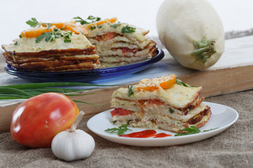Vegetable cake with zucchini, tomatoes, cheese, onions and garlic served on plate