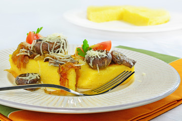 Fried polenta triangles with mushrooms, cheese and caramelized onion.