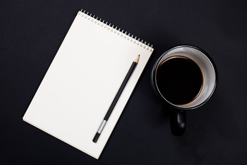 white paper notepad and a cup of coffee on black chalkboard back