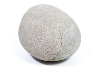 Natural stone of rounded shape on white background. Selective focus with shallow depth of field.