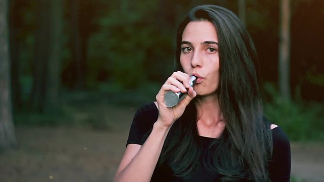 Beautiful woman smoking an e-cigarette 