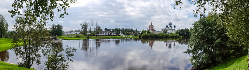 Fototapeta na wymiar Panorama Tikhvin assumption male monastery, it is the Tikhvin icon of the mother of God. The Orthodox Church of Russia. The temple on the banks of the Tikhvinka river in Tikhvin.