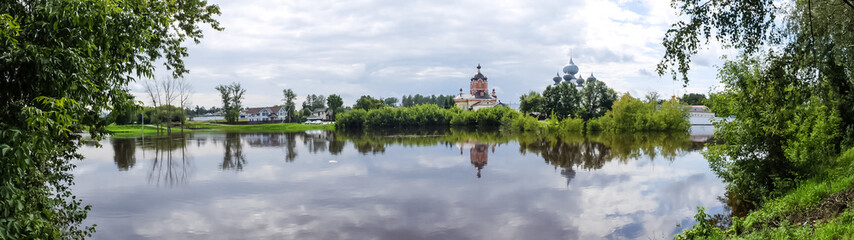 Fototapeta na wymiar Panorama Tikhvin male monastery - it is Tikhvin icon of the mother of God. The Orthodox Church of Russia. The temple on the banks of the Tikhvinka river in Tikhvin.