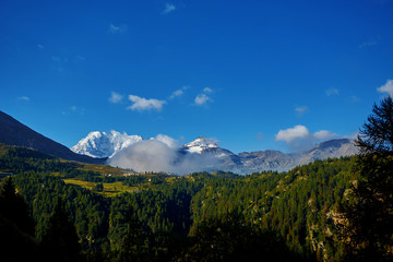 Snow capped mountains under deep blue sky.