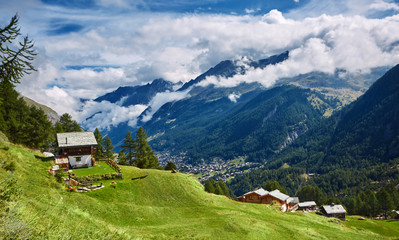 Fototapeta na wymiar Alpine meadow with houses at afternoon, around Zermatt