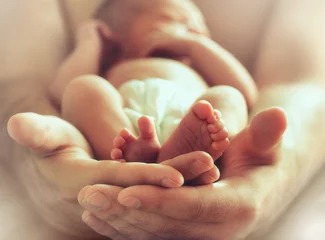 Fotobehang sleeping newborn baby on male hands © BazziBa