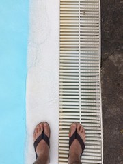 Feet in flipflops by the pool