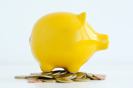 Yellow piggy bank isolated on white background suggesting family savings concept