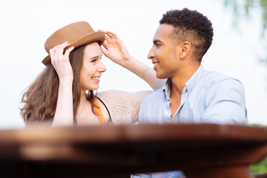 Young couple messing around with pork pie hat smiling